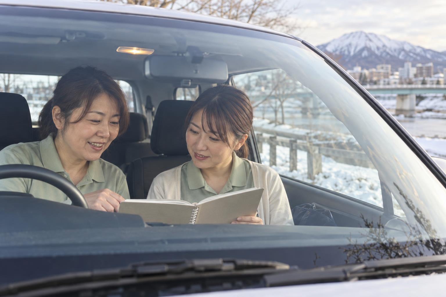 訪問のあと、車の中で先輩と振り返る看護師